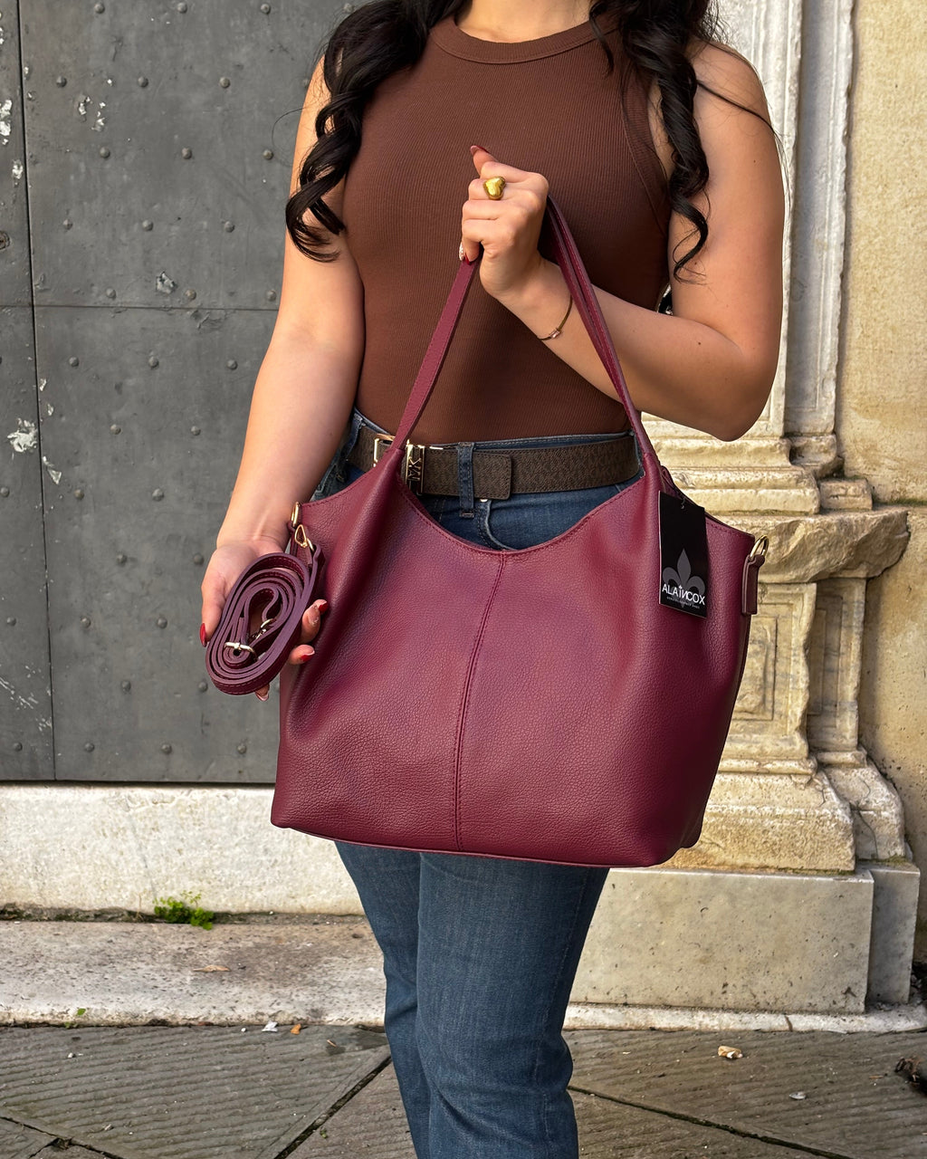 Borsa LOLA in vera pelle martellata, capiente ed elegante, con dettagli in acciaio inox dorato. Dotata di chiusura con zip, interno foderato con tasca interna e tracolla regolabile in vera pelle, è perfetta per un look raffinato e pratico ogni giorno. ALAINCOX Genova Via di fossatello 