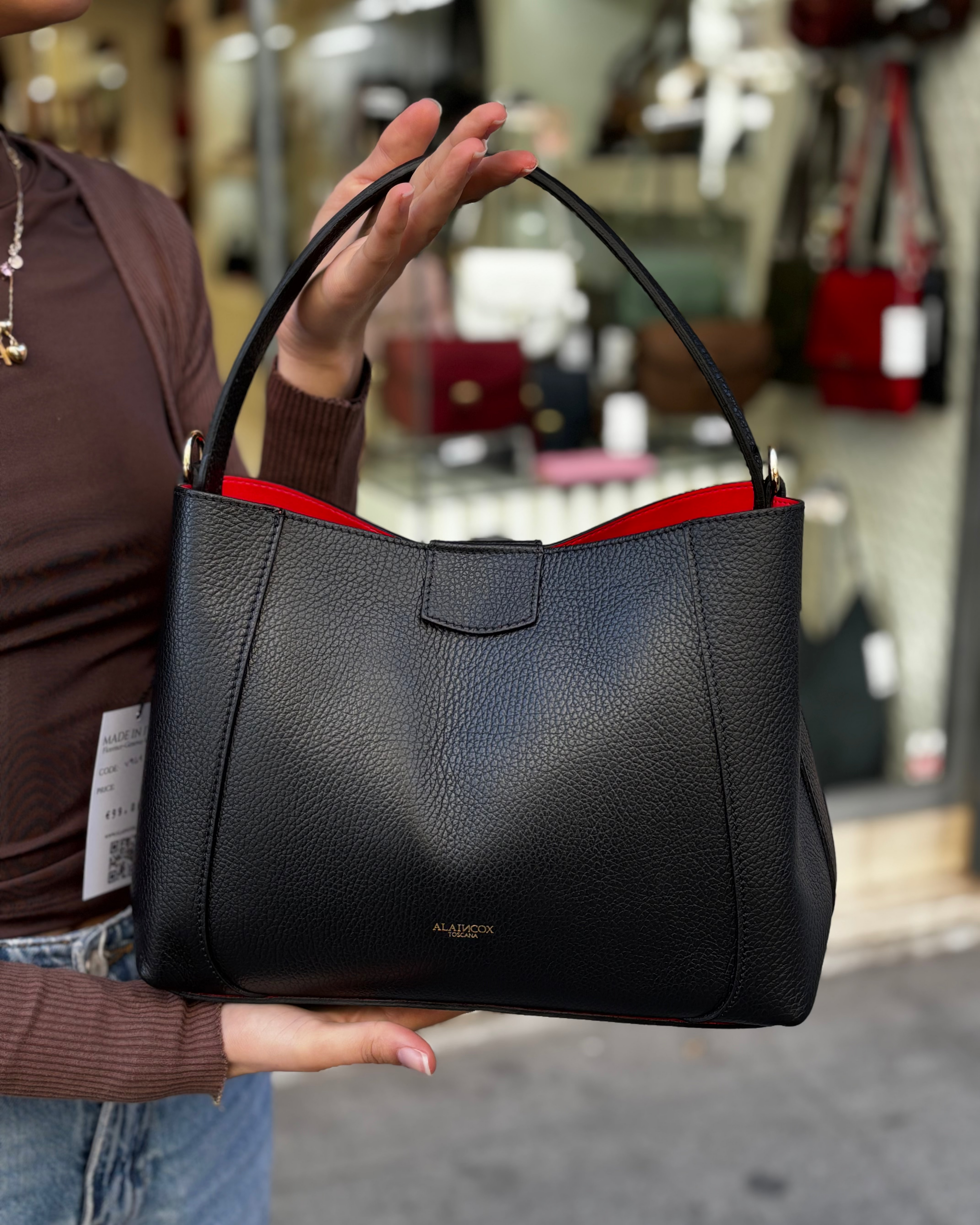 Borsa melina da donna in vera pelle martellata made in italy, colore nero, firmata Alaincox, negozio di Genova, con pochette interna con zip, tracolla regolabile e dettagli in acciaio dorato, elegante e capiente per uso quotidiano.