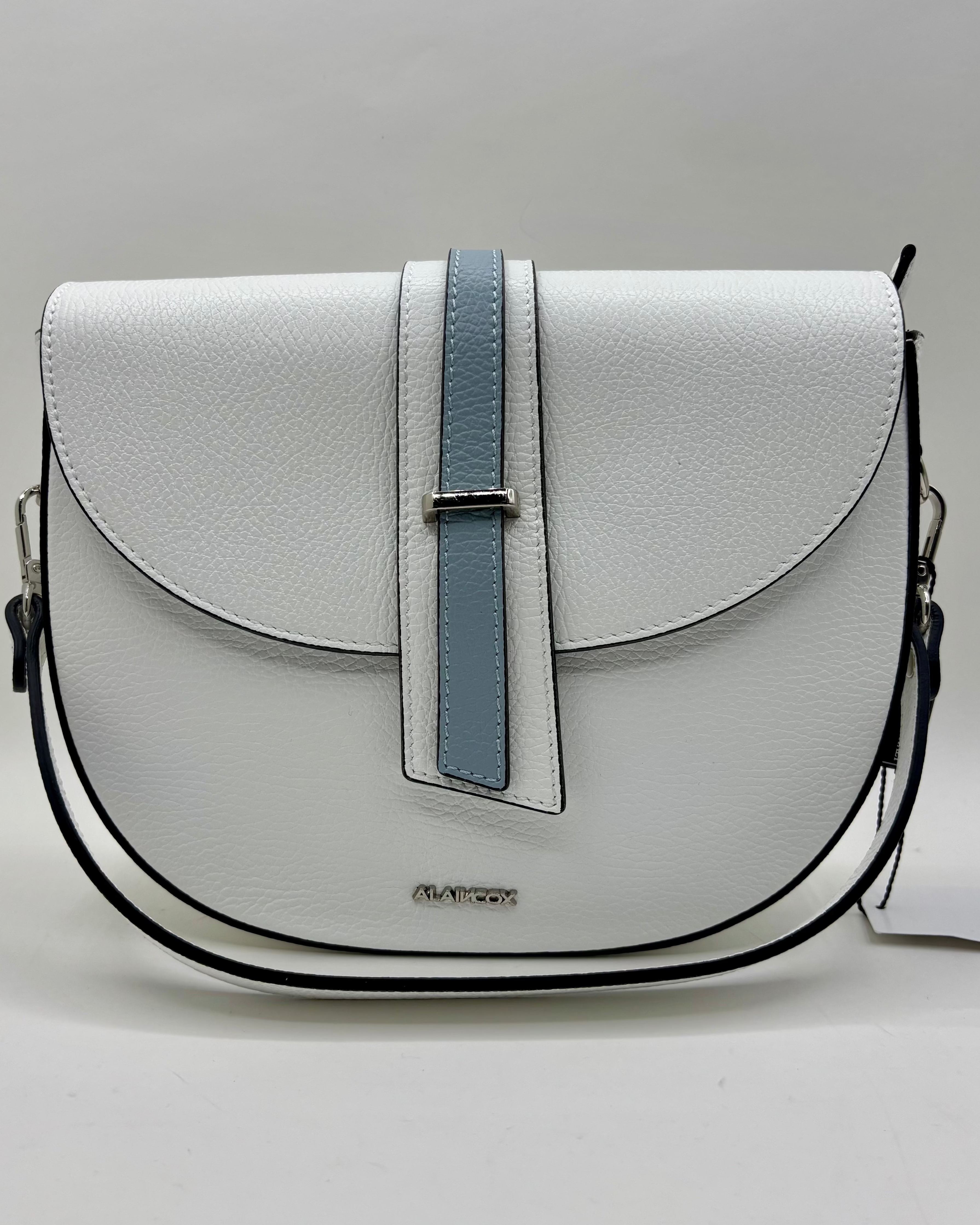 La Borsa Sofia di ALAINCOX è una tracolla in vera pelle martellata Made in Italy, elegante e resistente, con design bianco e celeste, doppia chiusura magnetica e zip, hardware in acciaio inox e tracolla regolabile. Perfetta per l’uso quotidiano grazie alle dimensioni compatte 26×20×9 cm.
