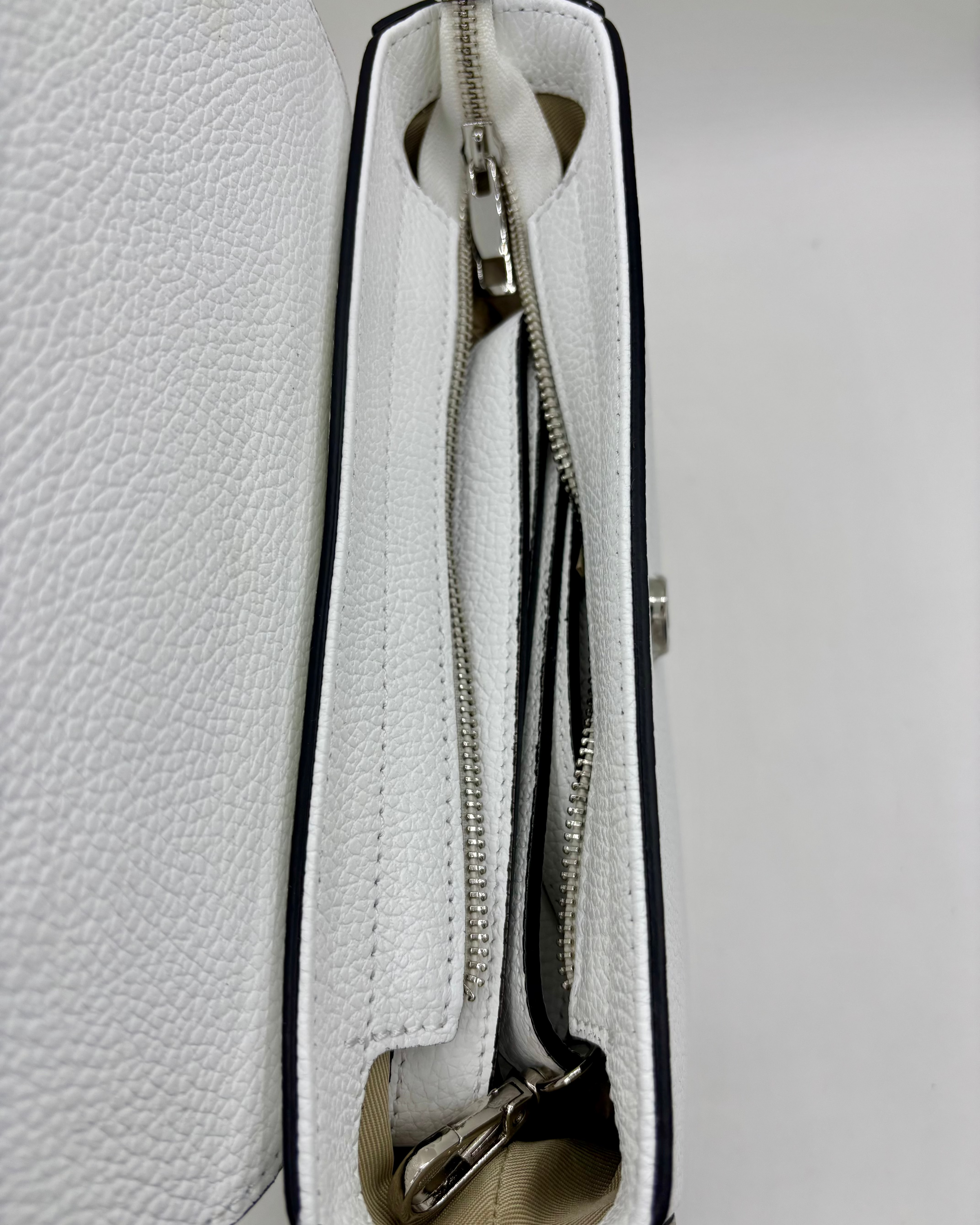 La Borsa Sofia di ALAINCOX è una tracolla in vera pelle martellata Made in Italy, elegante e resistente, con design bianco e celeste, doppia chiusura magnetica e zip, hardware in acciaio inox e tracolla regolabile. Perfetta per l’uso quotidiano grazie alle dimensioni compatte 26×20×9 cm.
