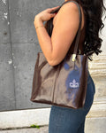 Borsa zaino ELBA in vera pelle Made in Italy, realizzata con pelle premium a conciatura vegetale artigianale. Elegante e versatile, utilizzabile come borsa o zaino, con dettagli in acciaio inox color ottone e interno organizzato con tasca zip. ALAINCOX GENOVA 
testa di moro
