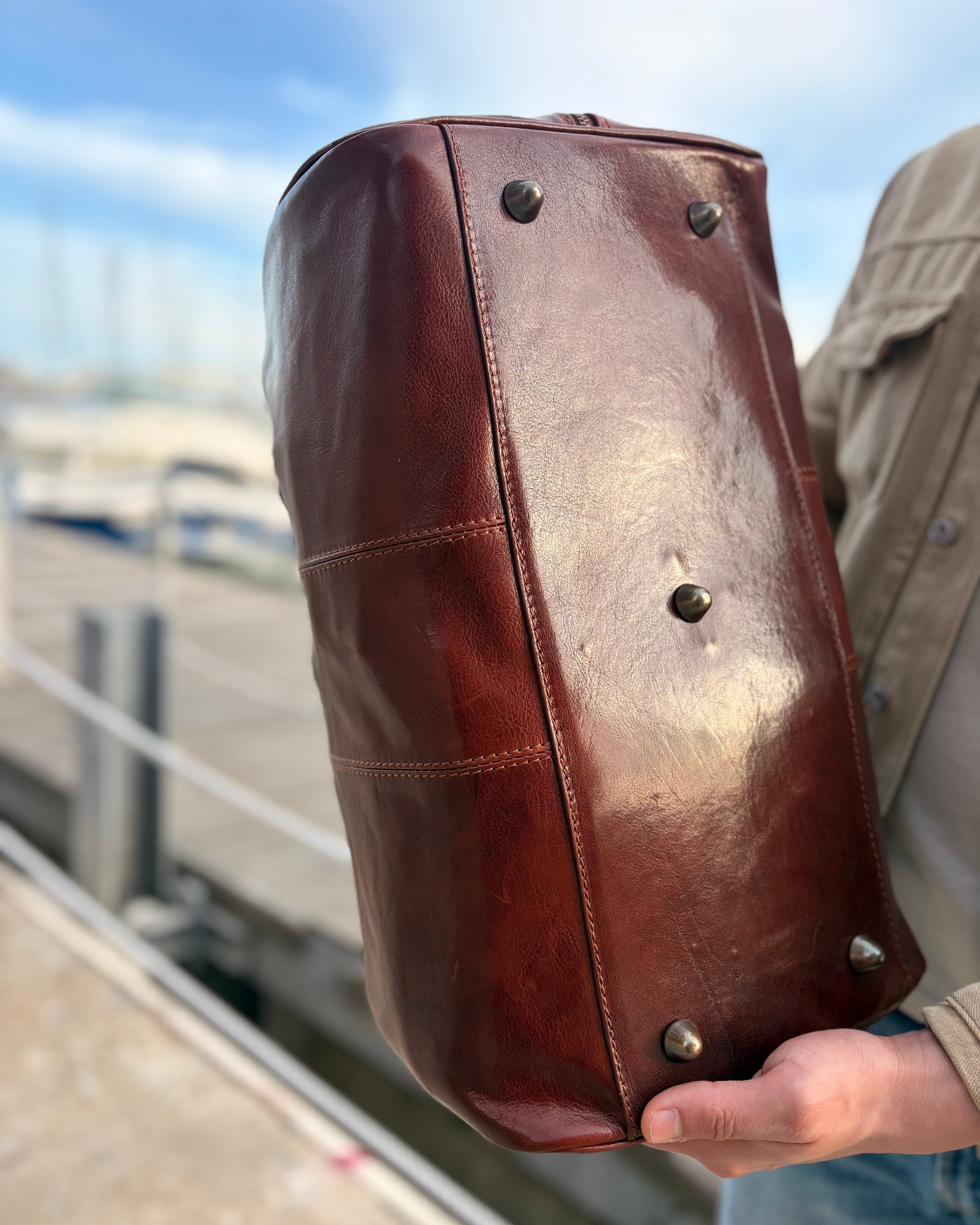 Borsone MICHELANGELO in cuoio – Made in Italy

Borsone unisex in vera pelle oliata con conciatura vegetale, realizzato a mano secondo la tradizione artigianale italiana. Resistente, elegante e ideale per viaggi o uso quotidiano, con tracolla regolabile e tasca interna con cerniera.

Un prodotto in cuoio di alta qualità, simbolo della pelletteria Made in Italy.

Disponibile anche nel nostro negozio a Genova.

Dimensioni: 45 x 27 x 24 cm