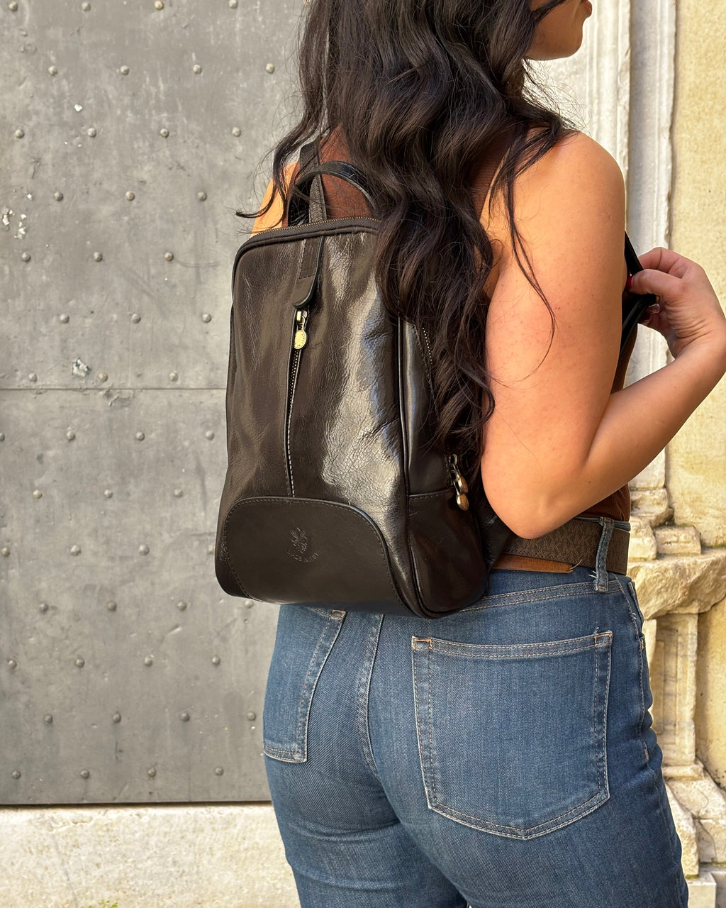 Zaino CARRARA in vera pelle Made in Italy, realizzato artigianalmente con pelle premium a conciatura vegetale. Elegante e funzionale, presenta dettagli in acciaio inox color ottone, tasche con zip, interno foderato con monogramma Made in Italy e spallacci regolabili per il massimo comfort quotidiano. ALAINCOX GENOVA 