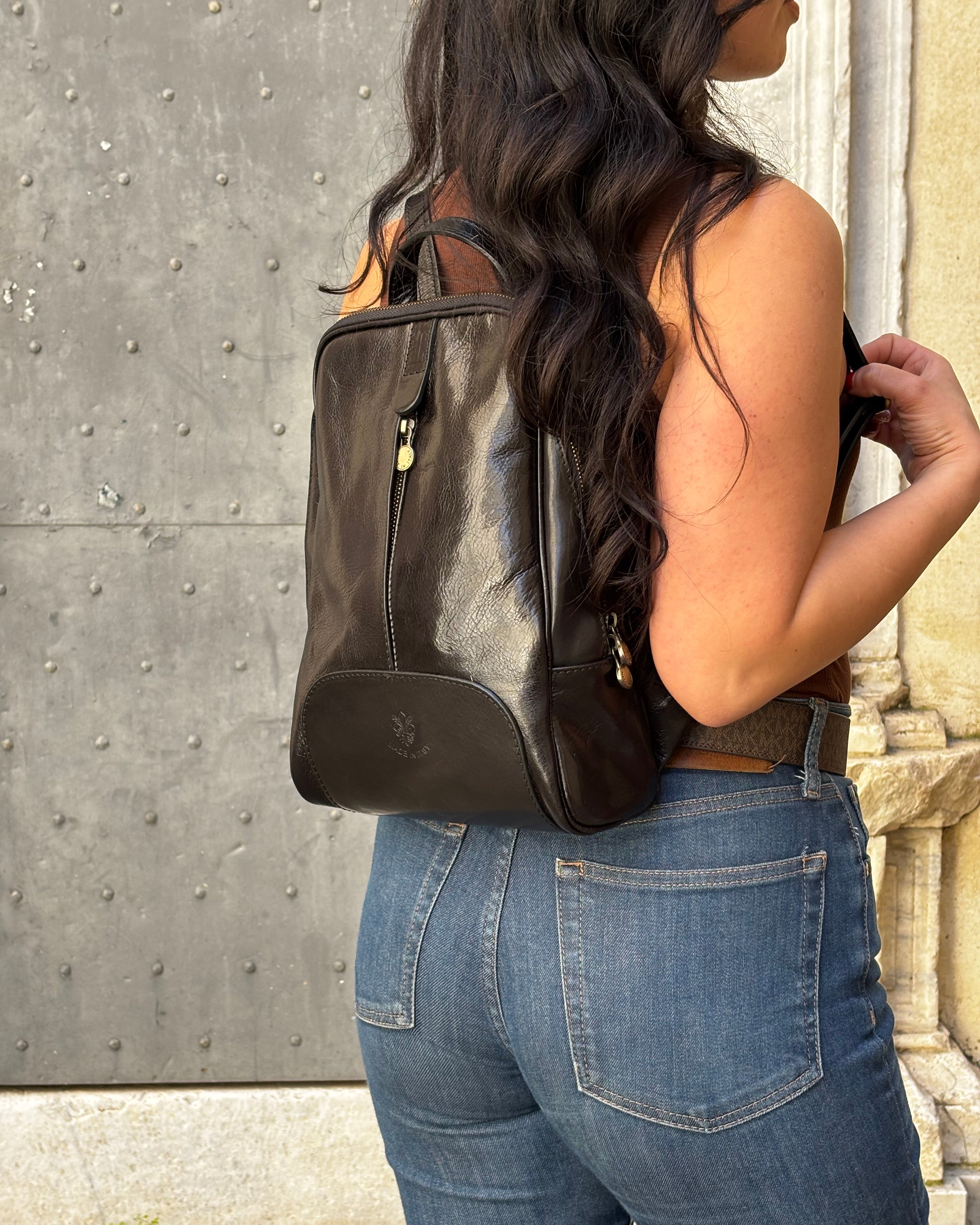 Zaino CARRARA in vera pelle Made in Italy, realizzato artigianalmente con pelle premium a conciatura vegetale. Elegante e funzionale, presenta dettagli in acciaio inox color ottone, tasche con zip, interno foderato con monogramma Made in Italy e spallacci regolabili per il massimo comfort quotidiano. ALAINCOX GENOVA 