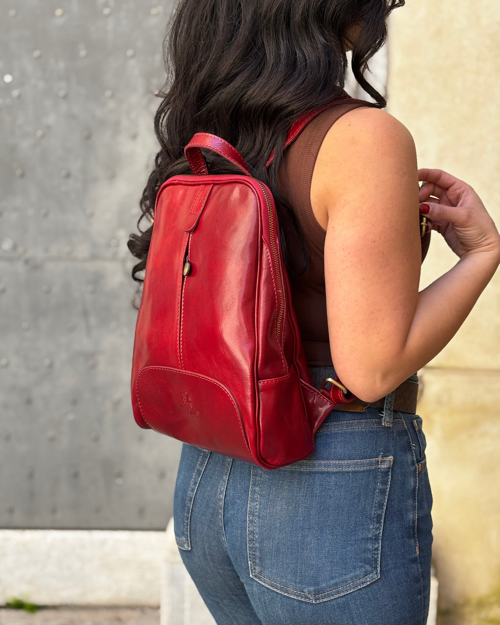 Zaino CARRARA in vera pelle Made in Italy, realizzato artigianalmente con pelle premium a conciatura vegetale. Elegante e funzionale, presenta dettagli in acciaio inox color ottone, tasche con zip, interno foderato con monogramma Made in Italy e spallacci regolabili per il massimo comfort quotidiano. ALAINCOX GENOVA 