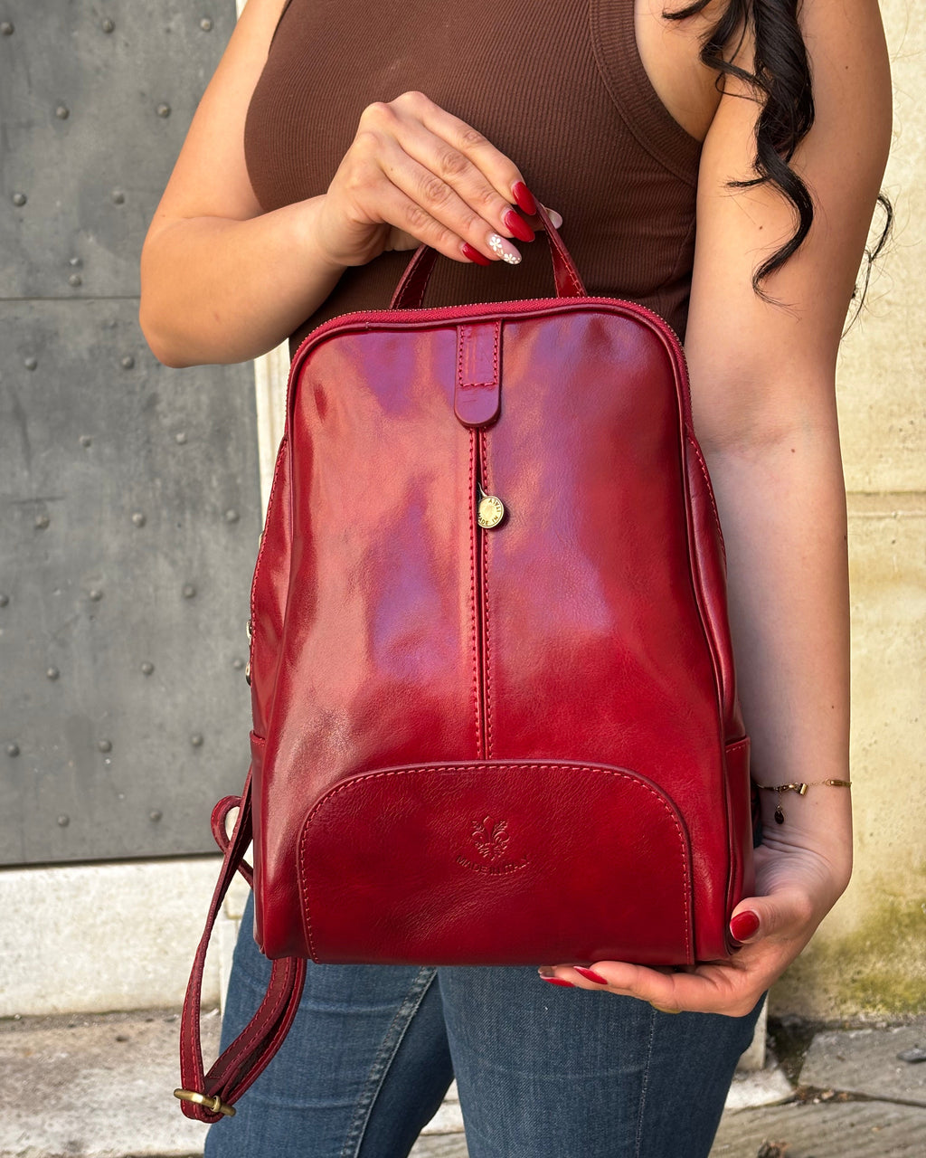 Zaino CARRARA in vera pelle Made in Italy, realizzato artigianalmente con pelle premium a conciatura vegetale. Elegante e funzionale, presenta dettagli in acciaio inox color ottone, tasche con zip, interno foderato con monogramma Made in Italy e spallacci regolabili per il massimo comfort quotidiano. ALAINCOX GENOVA 
